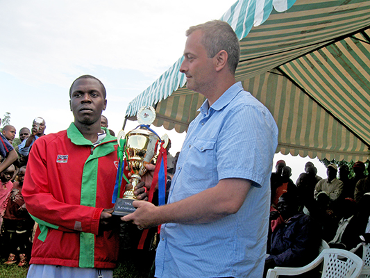 a man awarding a trophy to another man