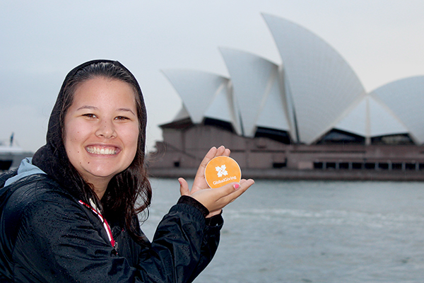 woman with a GlobalGiving sticker in front of the Sydney Opera House